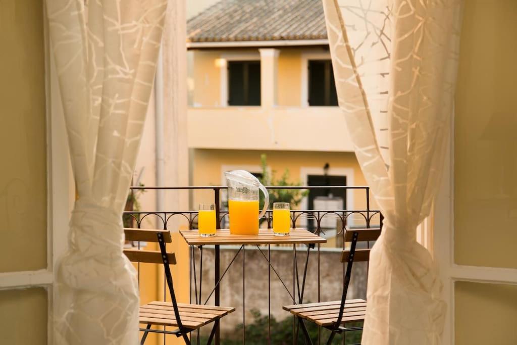 una mesa con 2 vasos de zumo de naranja en el balcón en Orfeas House Corfu, en Corfú