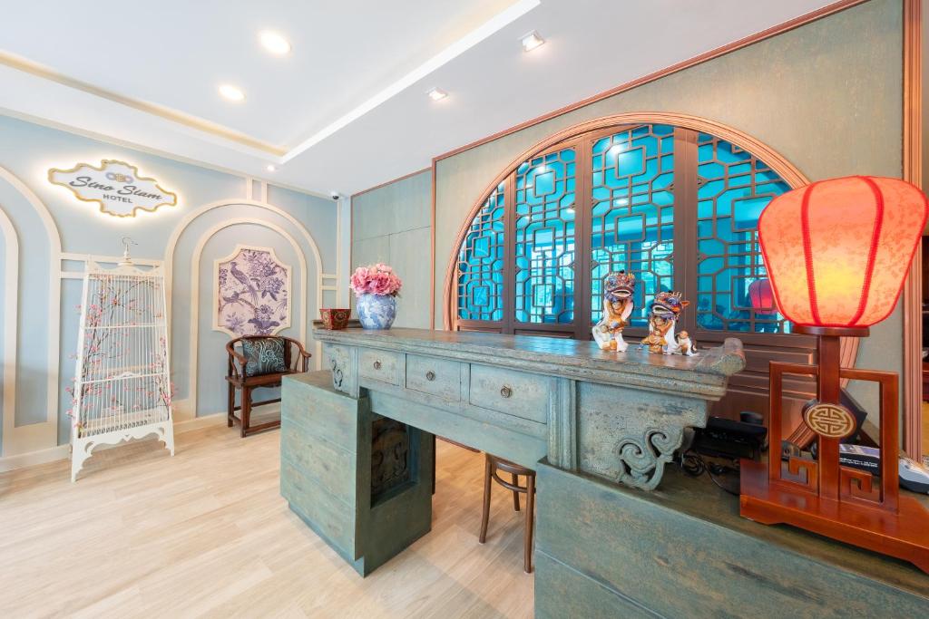 a room with a desk and a stained glass window at Sino Siam Hotel in Klong Muang Beach