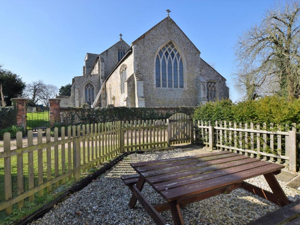 a wooden bench sitting in front of a church at 2 Bed in South Creake KT117 in North Creake