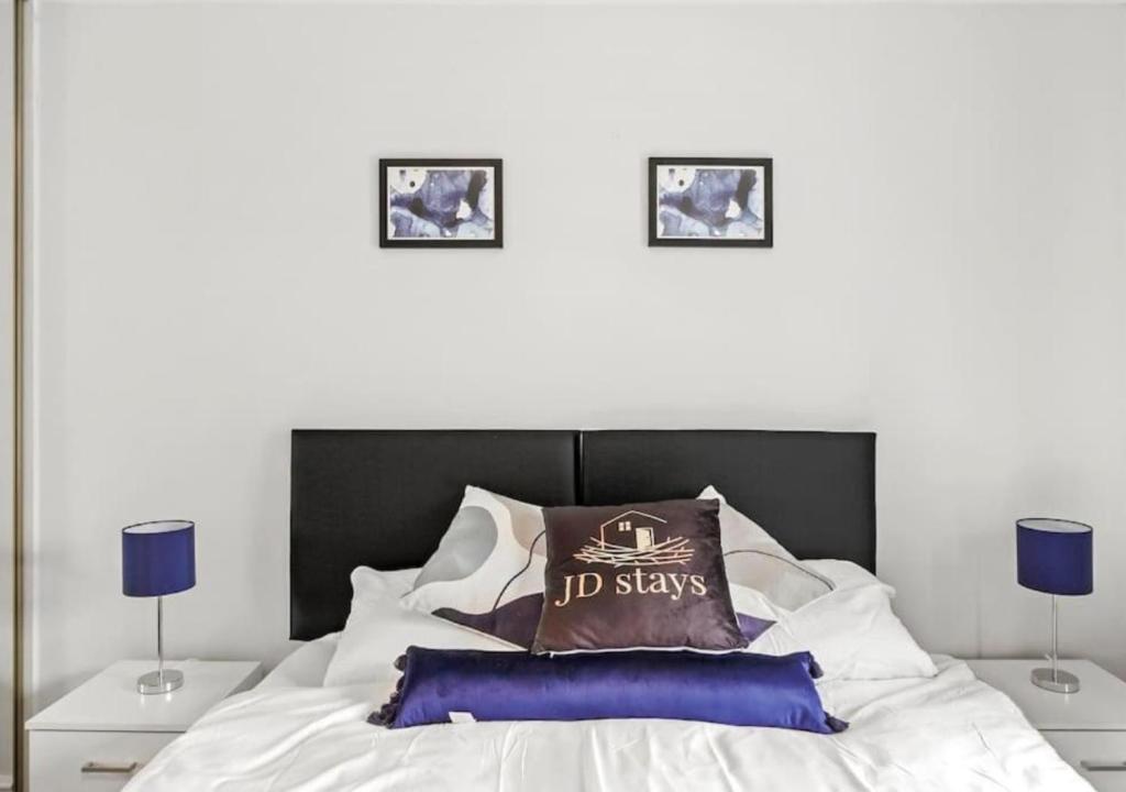 a bedroom with a bed with two pictures on the wall at Relaxing Family Hideaway - Stay Longer, Save More! in North Hykeham