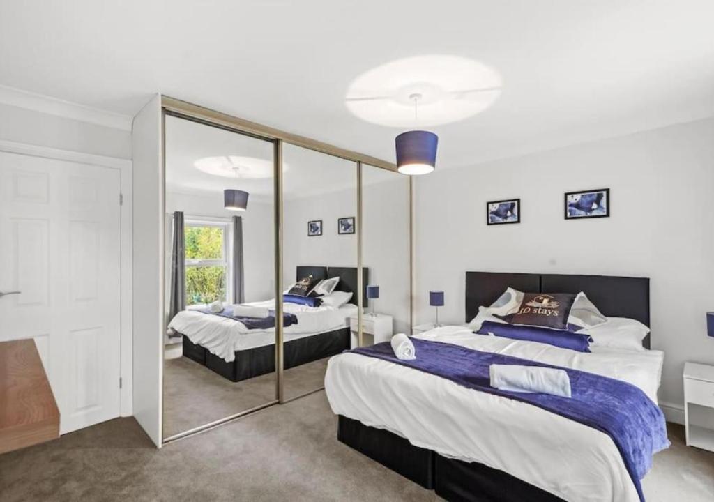 um quarto com 2 camas e um espelho grande em 3 Bedroom House, great location - Big special offer for long-term stays em North Hykeham
