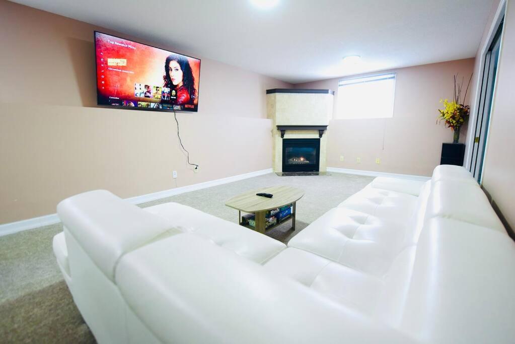 a living room with a white couch and a tv at Adorable Spacious Inn with Indoor fireplace in Kingston