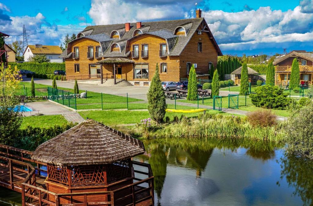 una casa grande con un estanque frente a ella en Dworek Tucholski, en Zblewo