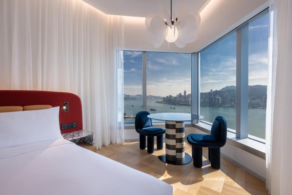 a hotel room with a bed and a table and chairs at Mondrian Hong Kong in Hong Kong