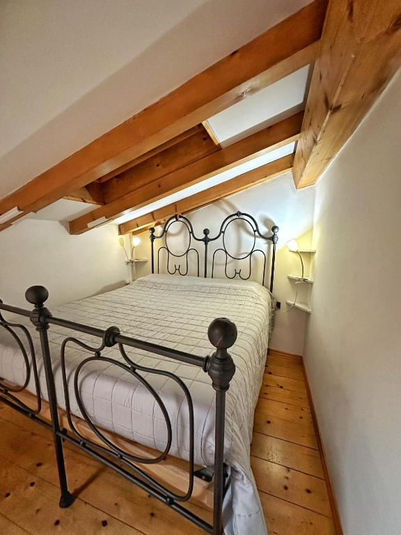特伦托Casa Mazzini的阁楼上的卧室配有金属床