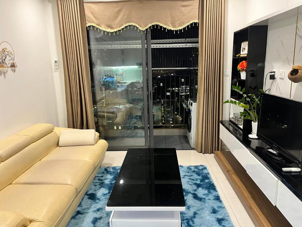 a living room with a couch and a large window at Skyhome in Gia Lâm Pho
