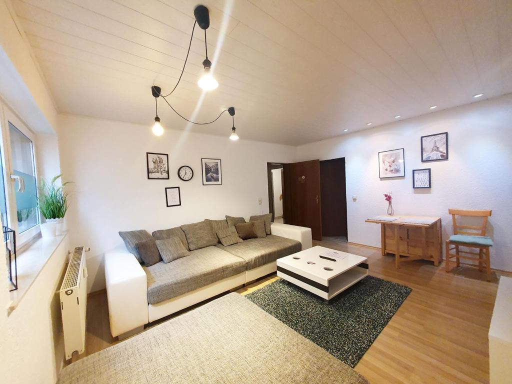 ein Wohnzimmer mit einem Sofa und einem Tisch in der Unterkunft Cozy Apartments in Limeshain in Hainchen