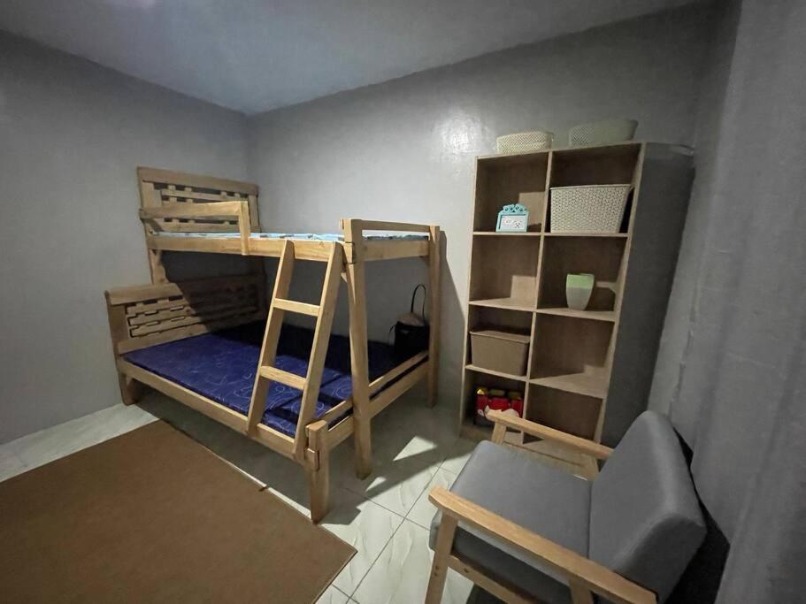 um quarto com 2 beliches e uma cadeira em 2B Tiny Home in Iba Zambales em Iba