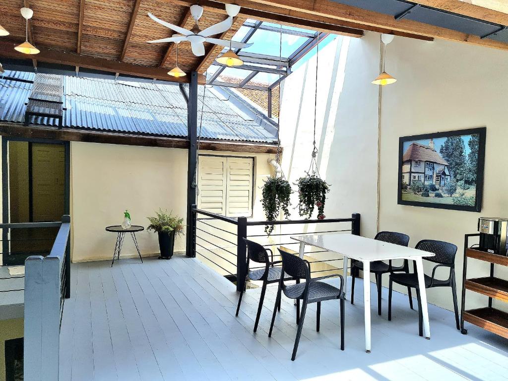 una terraza con mesa, sillas y ventilador de techo. en Stewart Hotel at 67 By EVR - Newly Renovated 2024, en George Town