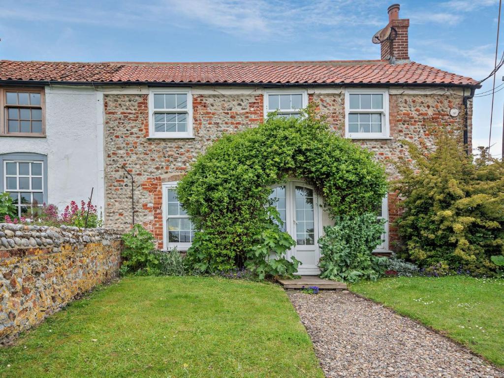 a brick house with a white door and ivy at 2 Bed in Salthouse NCC15 in Salthouse
