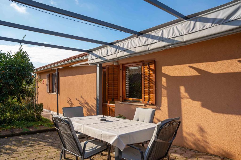a patio with a white table and chairs at Garden house Kablar in Pula