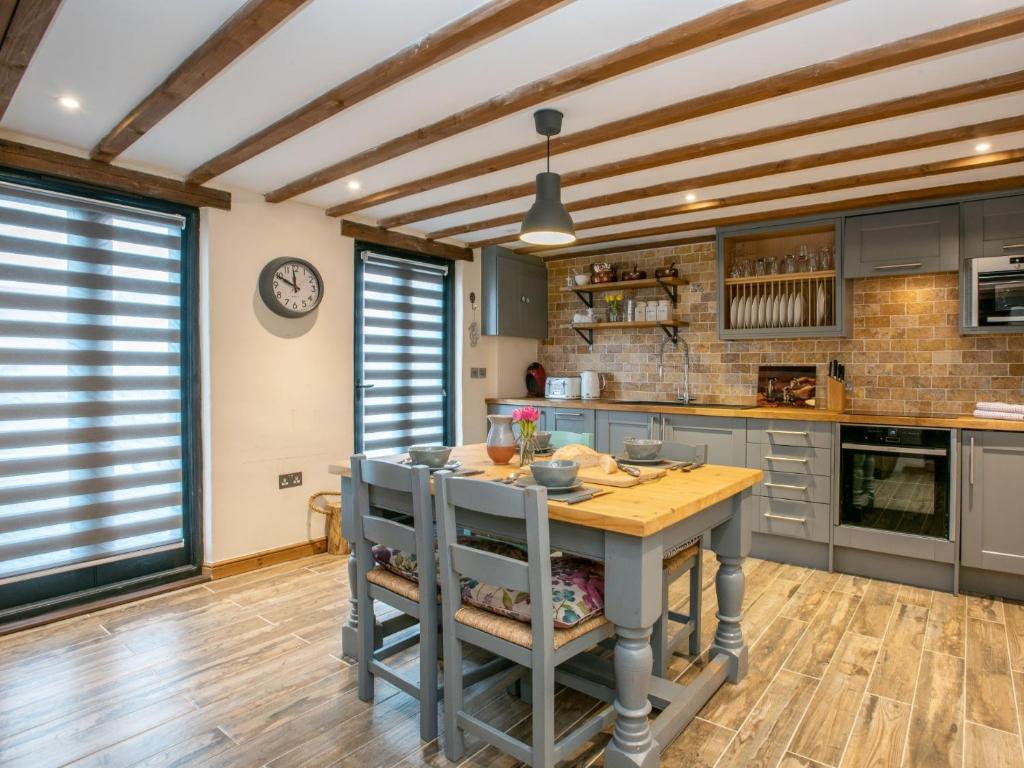 a kitchen with a table and a clock on the wall at 2 Bed in Holt NCC41 in Holt