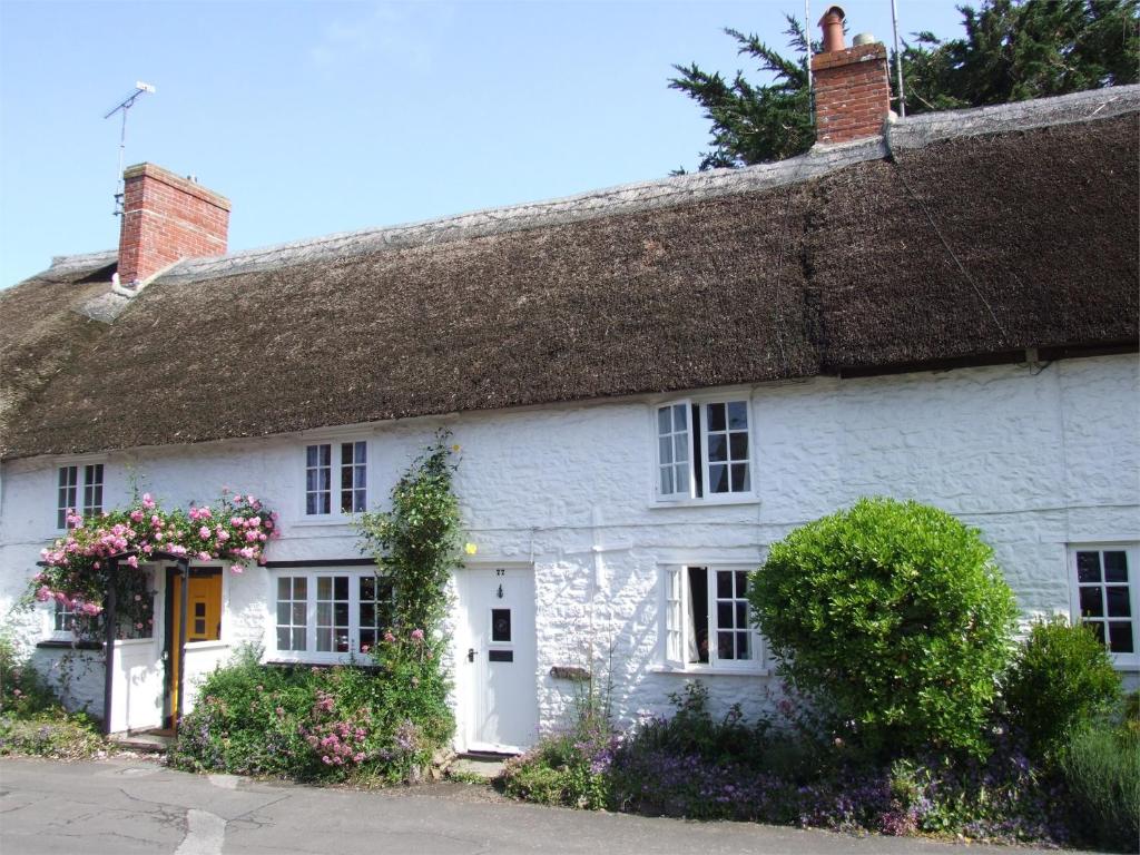a white cottage with a thatched roof at 1 Bed in Burton Bradstock DC016 in Burton Bradstock