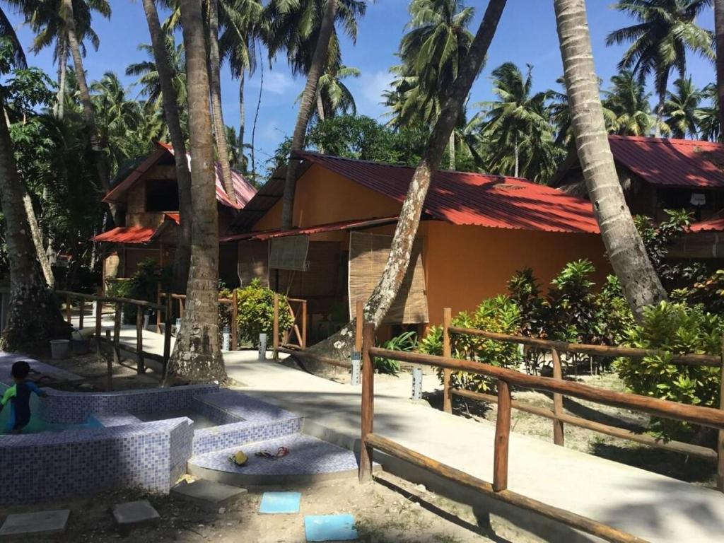 une maison avec des palmiers devant elle dans l'établissement Dreamland Resort , PORTBLAIR, à Havelock Island