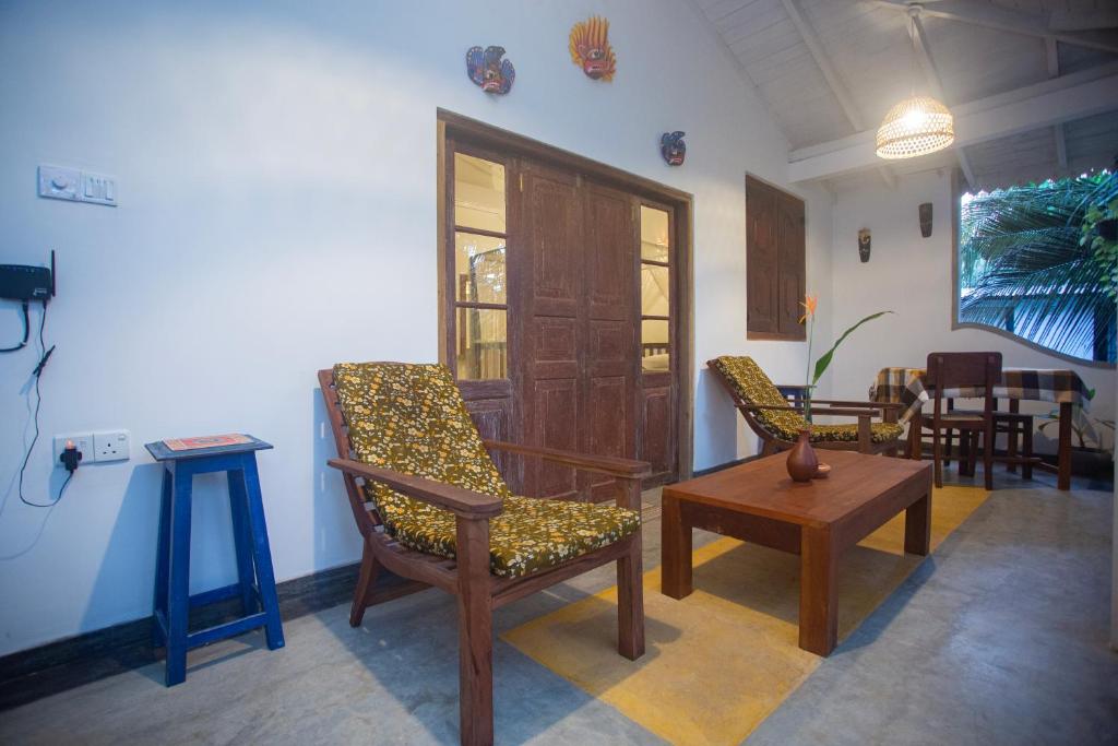 a living room with two chairs and a table at THE CHILLI STUDIO APARTMENT in Unawatuna