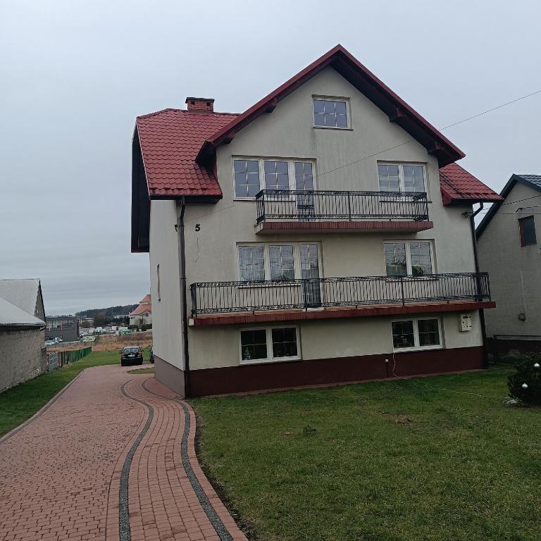 ein Haus mit rotem Dach und einer Ziegelsteinfahrt in der Unterkunft Noclegi w Bilczy 5 km do Kielc in Bilcza