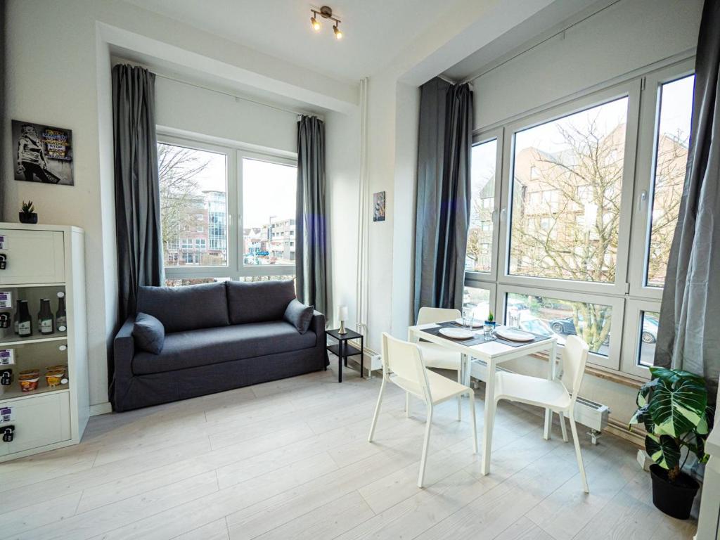 un soggiorno con tavolo, sedie e divano di Work & Stay in Ahrensburg bei Hamburg a Ahrensburg