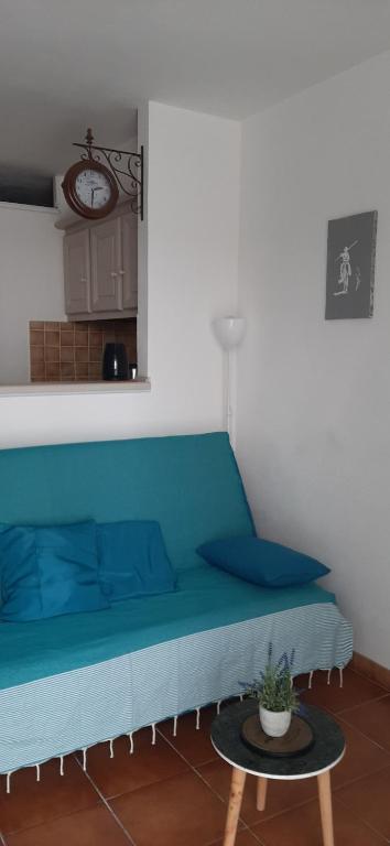 Sofá azul en una habitación con mesa en Appartement calme à deux pas de la mer, en Saintes-Maries-de-la-Mer