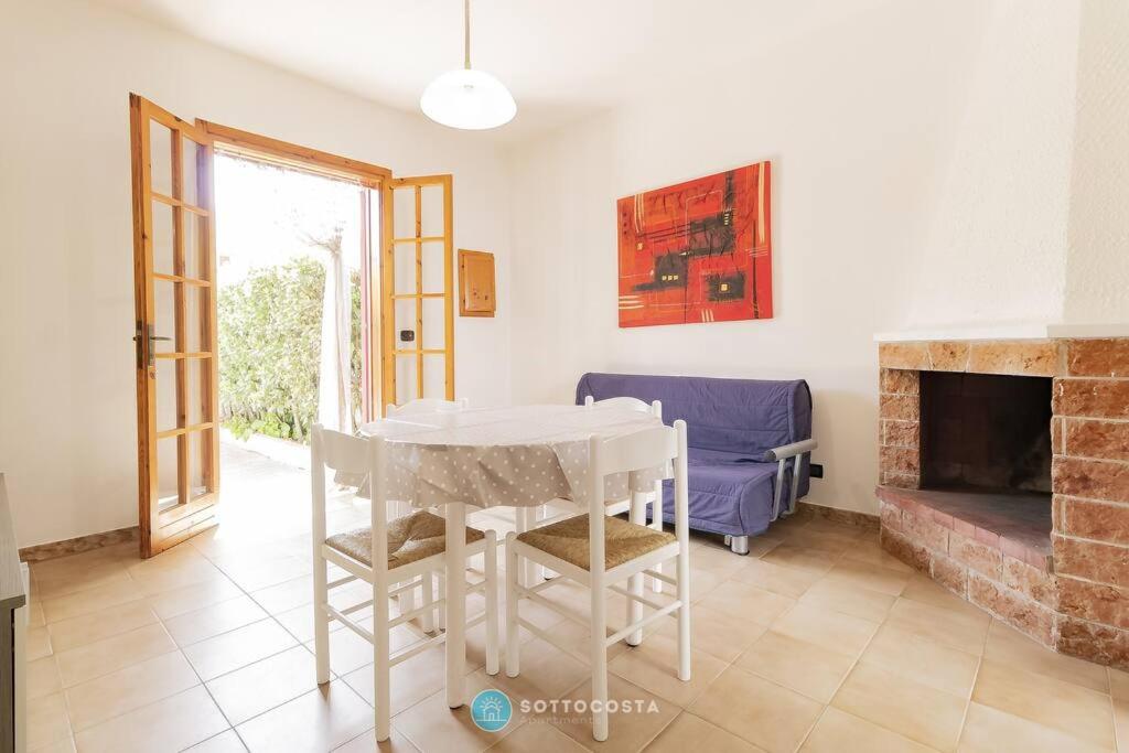 a dining room with a table and a fireplace at Orsetta Flat - Torre Dell'Orso in Torre dell'Orso