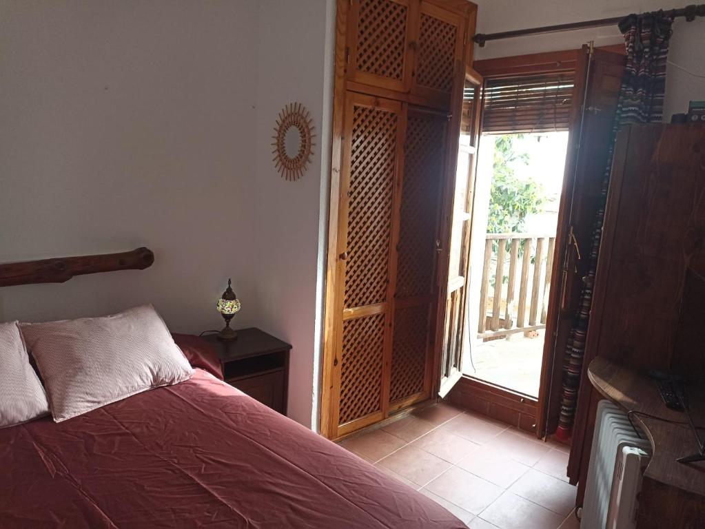 Un dormitorio con una cama y una puerta corrediza de vidrio. en La casita del castaño en Bubión, en Bubión