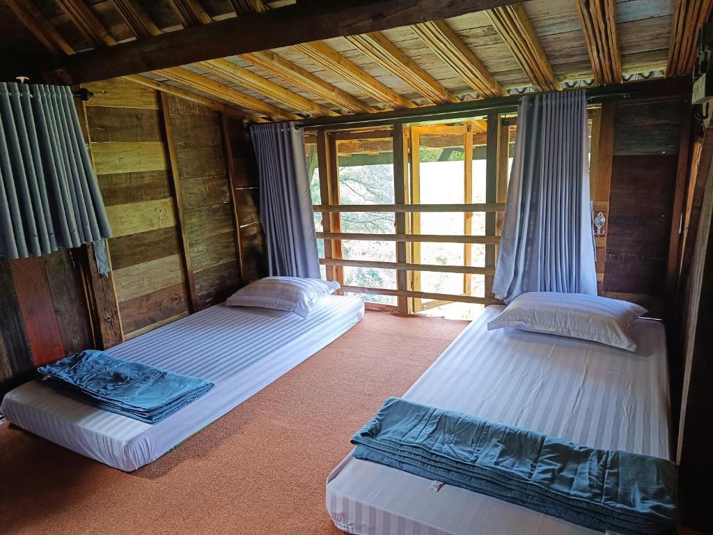 Zimmer mit 2 Betten in einem Haus in der Unterkunft Kebun Hanoman Villa in Pablengan