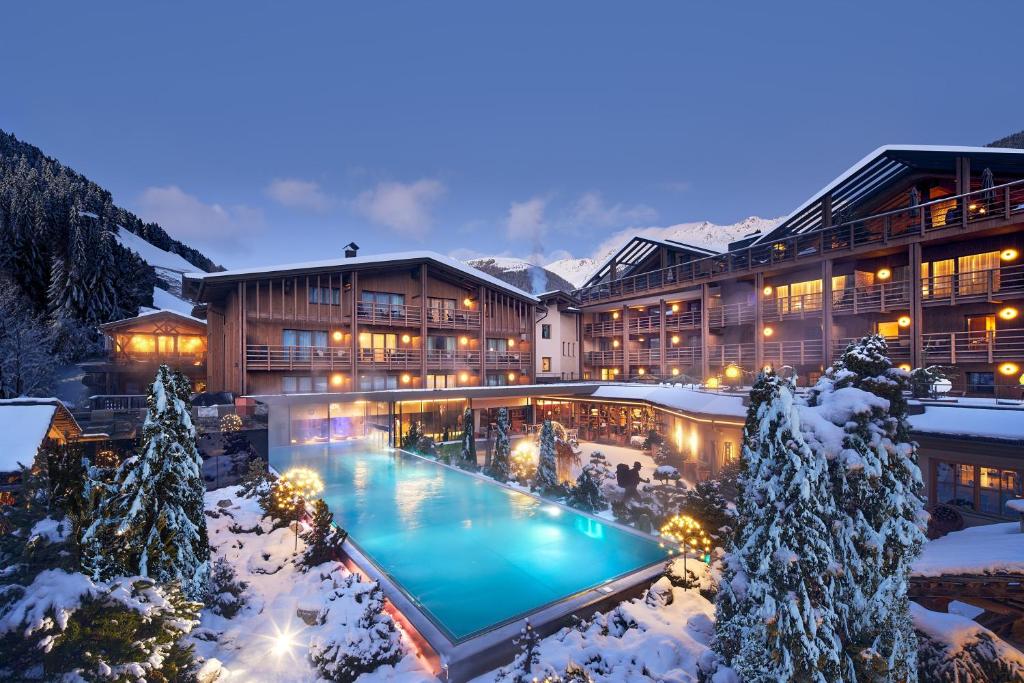 ein Hotel mit Pool im Schnee in der Unterkunft Hotel Quelle Nature Spa Resort in Santa Maddalena in Casies