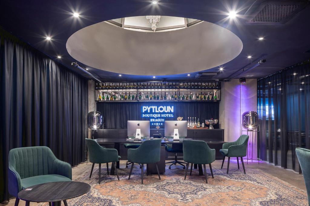 a dining room with a table and chairs and a bar at Pytloun Boutique Hotel Prague in Prague
