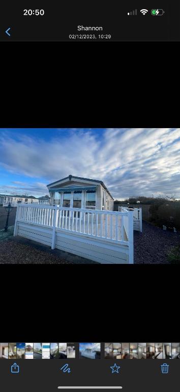 a picture of a house with a white fence at Modern caravan Robin Hood Rhyl in Rhyl