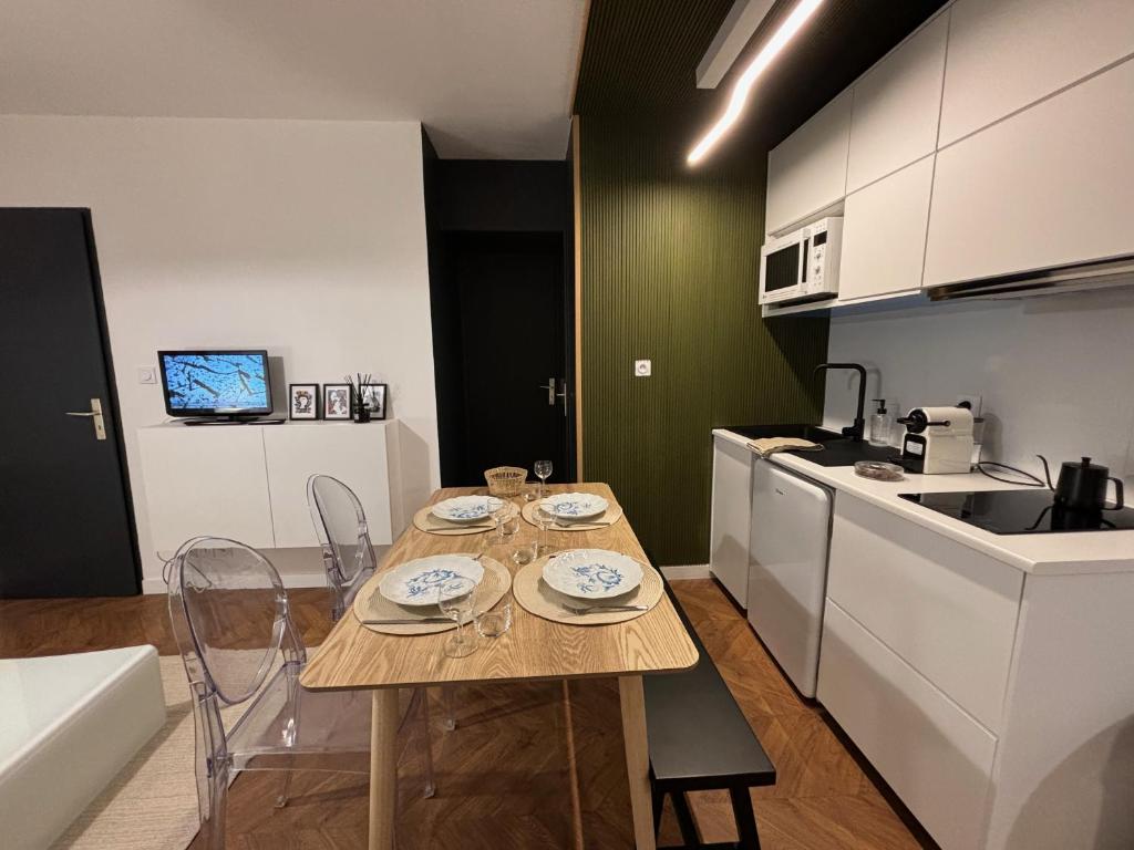 uma cozinha com mesa e cadeiras num quarto em Appartement au centre-ville à 100 m des télécabines avec parking souterrain gratuit em Luchon