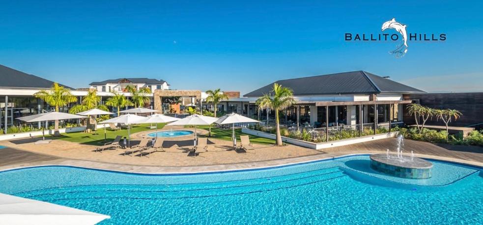 a swimming pool with umbrellas and a resort at Ballito Splash in Ballito