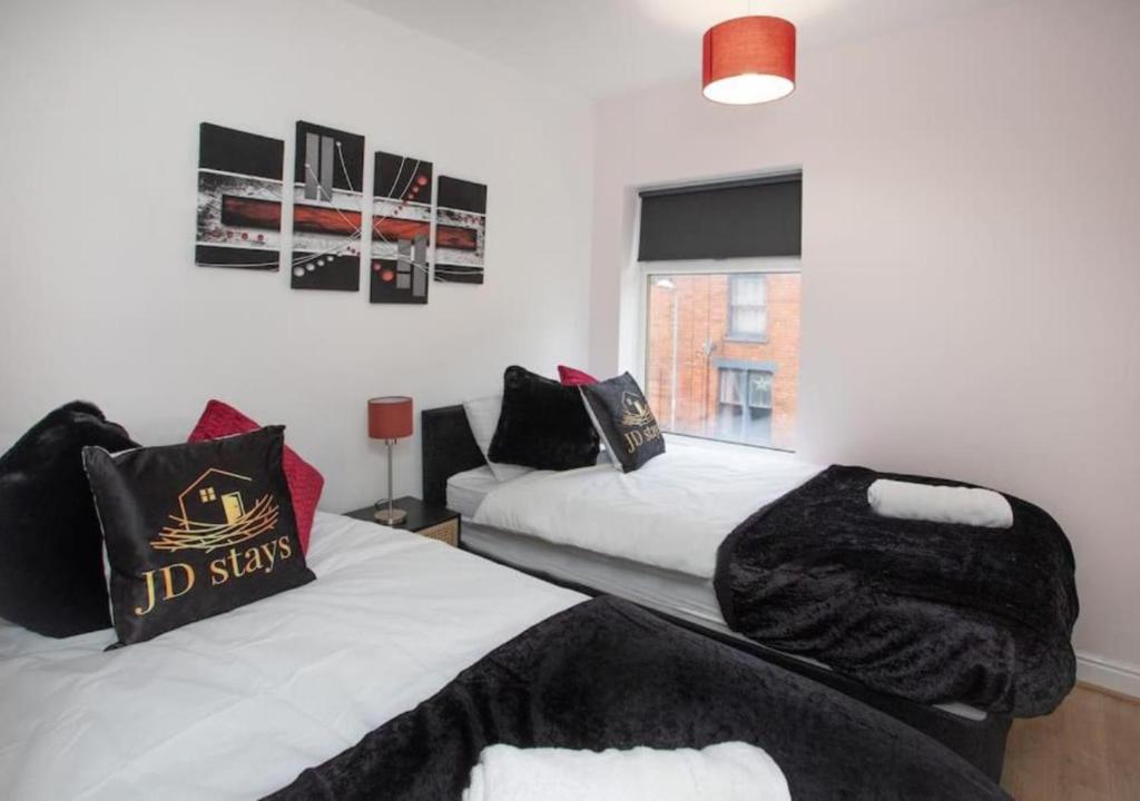 a bedroom with two beds and a couch at 4 Bedroom Apartment with Essentials - free private parking, private check-in and check-out and free WiFi in Lincolnshire