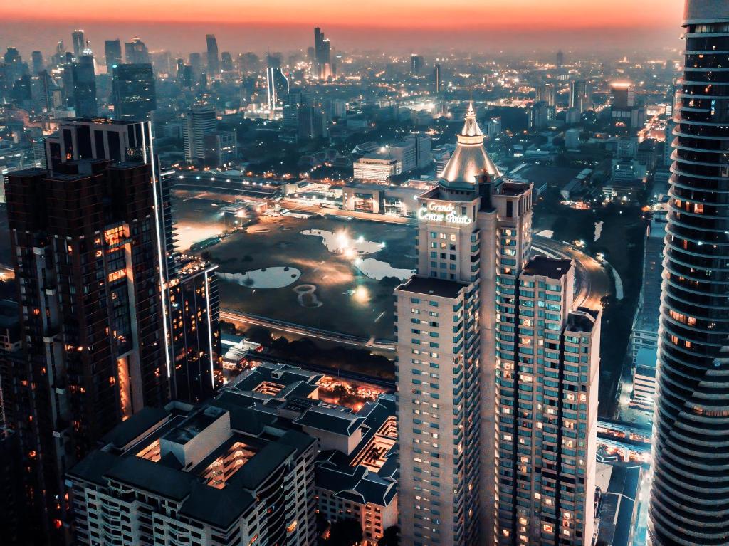 vistas a una ciudad por la noche con edificios altos en Grande Centre Point Hotel Ratchadamri Bangkok, en Bangkok