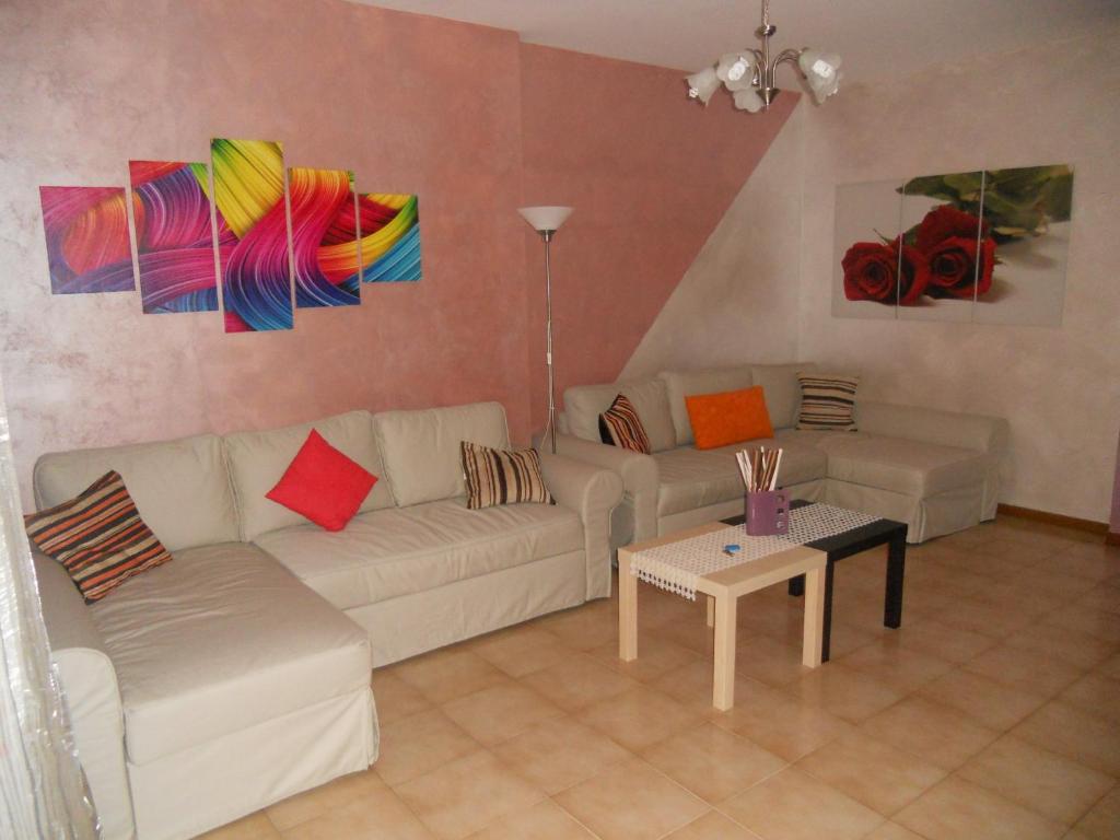 a living room with a white couch and colorful paintings at Pepita Flats in San Salvo