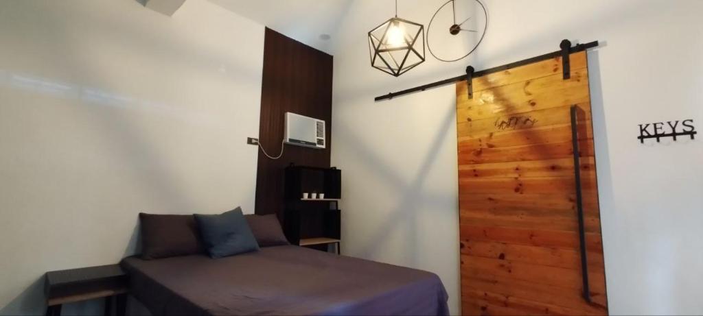 - une chambre avec un lit et une porte en bois dans l'établissement La Minimalista, à Bagac