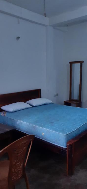 a bed in a room with a blue mattress at Daresh hime stay in Maskeliya