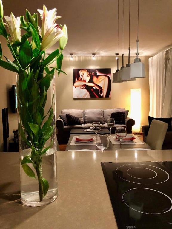 um vaso de flores numa mesa numa sala de estar em APARTAMENT STRUMYKOWA em Zielona Góra