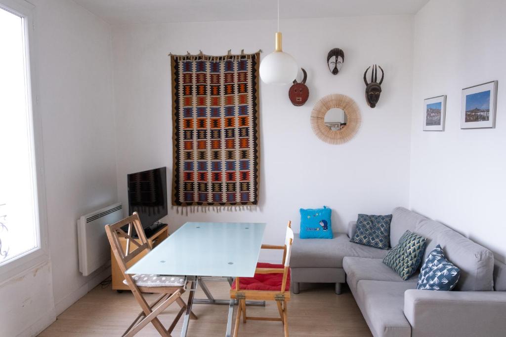 un salon avec un canapé et une table dans l'établissement Paris La Défense Appartement, à Courbevoie