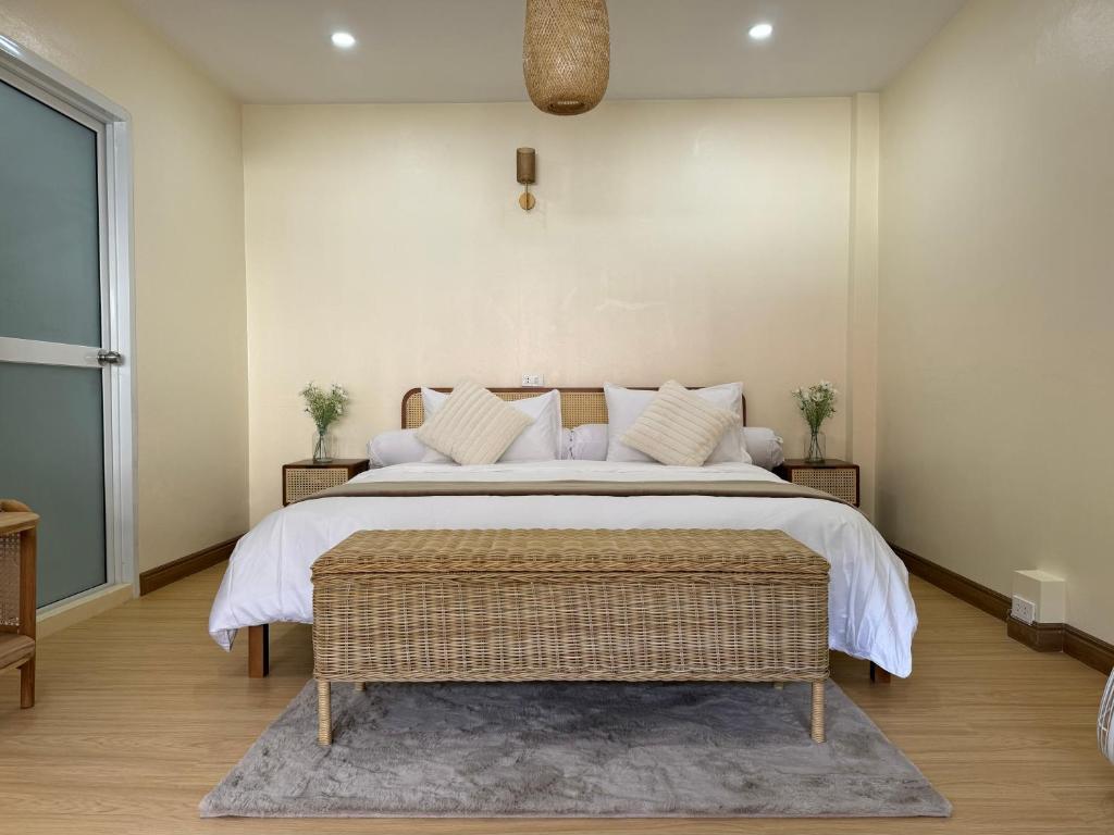 ein Schlafzimmer mit einem großen Bett mit weißer Bettwäsche und einem Teppich in der Unterkunft L’Oasis Nanai in Patong Beach