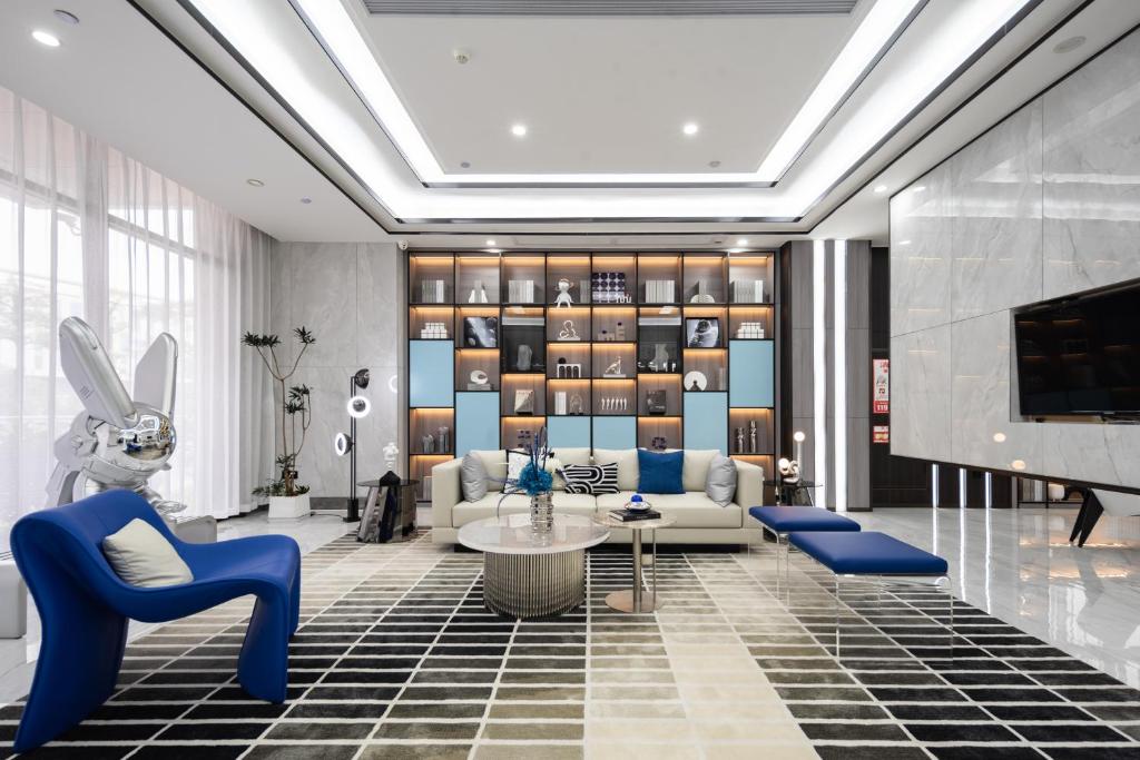 sala de estar con sillas azules y sofá en Jiayu Hotel - Guangzhou Baiyun International Airport T2 Terminal en Huadu