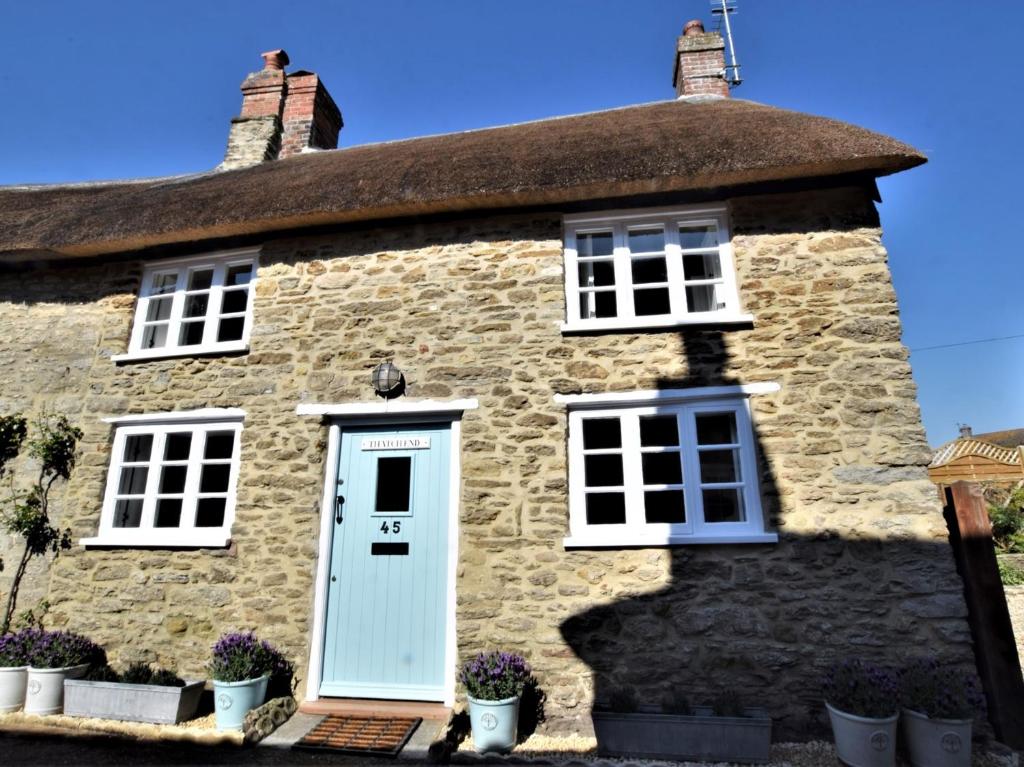 an old stone house with a blue door at 2 Bed in Burton Bradstock DC166 in Burton Bradstock