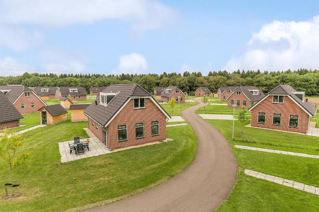 a road leading through a residential neighborhood with houses at Summio Villaparc Schoonhovenseland in Hollandscheveld