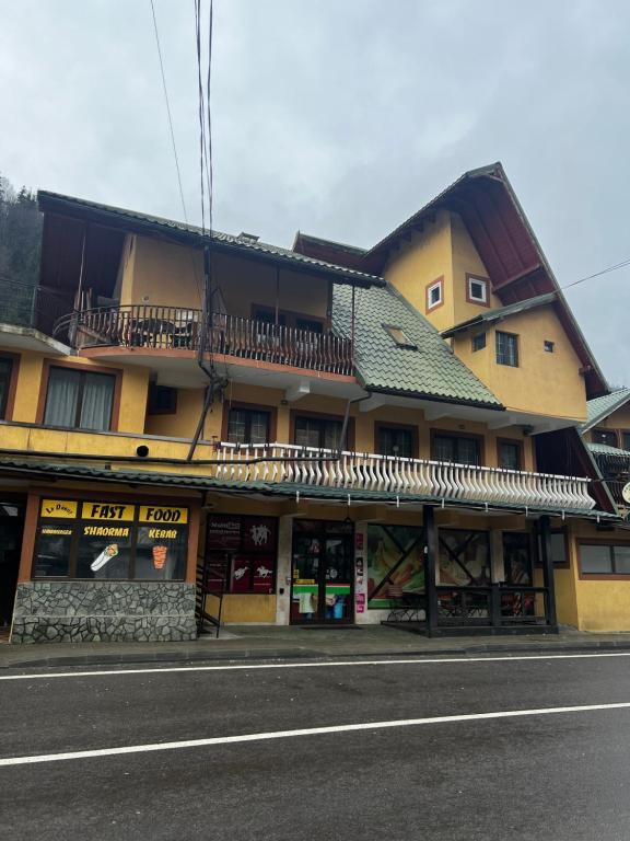 un edificio al lado de una calle en Pensiunea Dalia Voineasa, en Voineasa