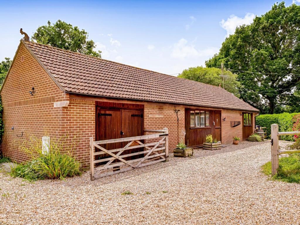 a brick barn with a wooden door and a fence at 3 Bed in Stoborough DC157 in Stoborough