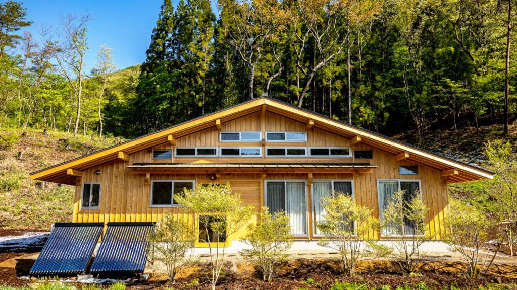 ein Haus mit Sonnenkollektoren davor in der Unterkunft Ecommodation 百のやど in Aone