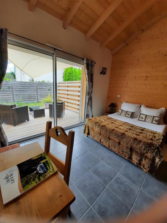 a bedroom with a bed and a large window at Au Cœur des Lacs - Chambres d'hôtes in Gérardmer