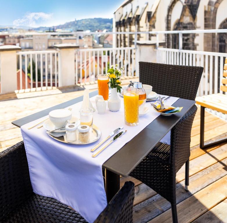 a table with a plate of food on a balcony at Pytloun Boutique Hotel Prague in Prague