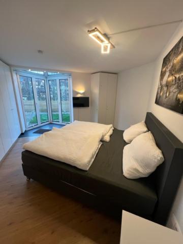 a bedroom with a black bed with white sheets and pillows at Ferien Haus Chino Bad Kissingen/Garitz in Bad Kissingen