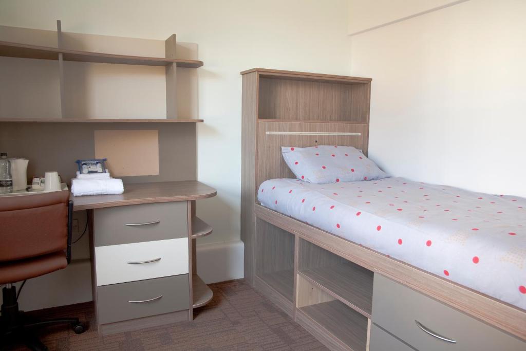 a bedroom with a bunk bed with a desk and a desk at Keynes College Budget Accommodation in Canterbury