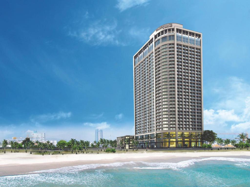 a tall building on the beach next to a beach at Luxury 2Bedroom Apartment with Ocean view 25th Floor in Da Nang