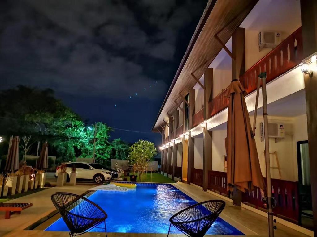 una piscina fuera de un edificio por la noche en BOSS HOTEL CHIANGMAl, en Chiang Mai